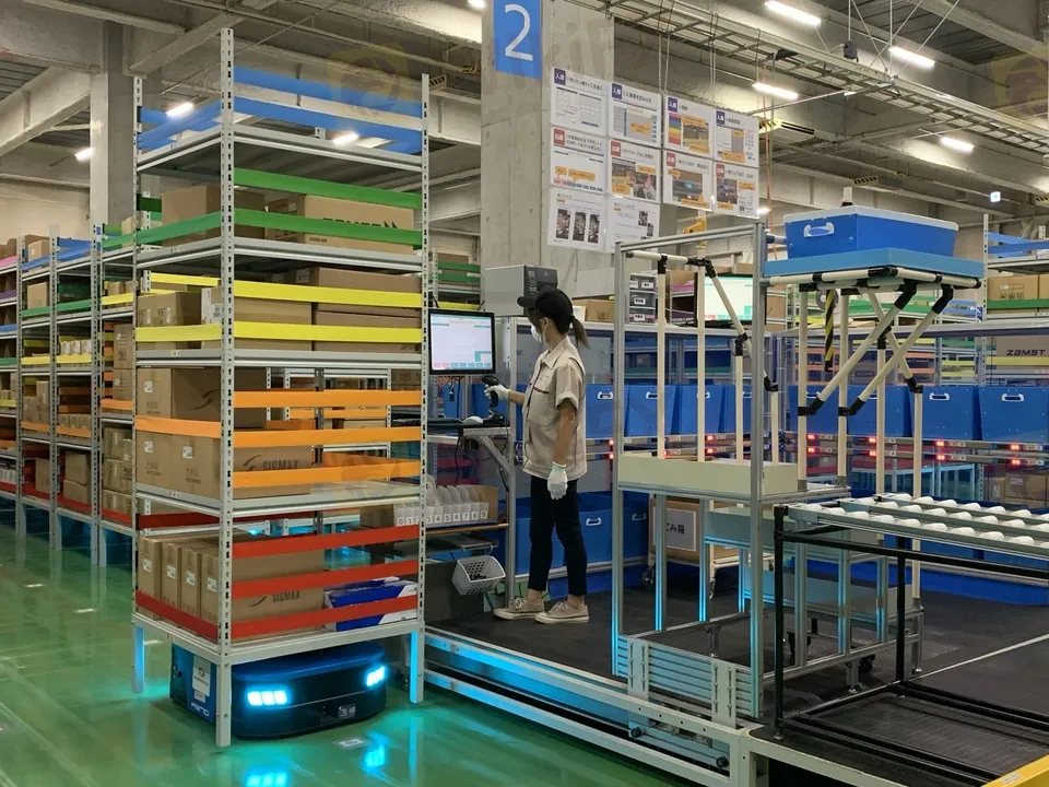 棚搬送ロボットが作業者の元へ荷物を運ぶ様子。