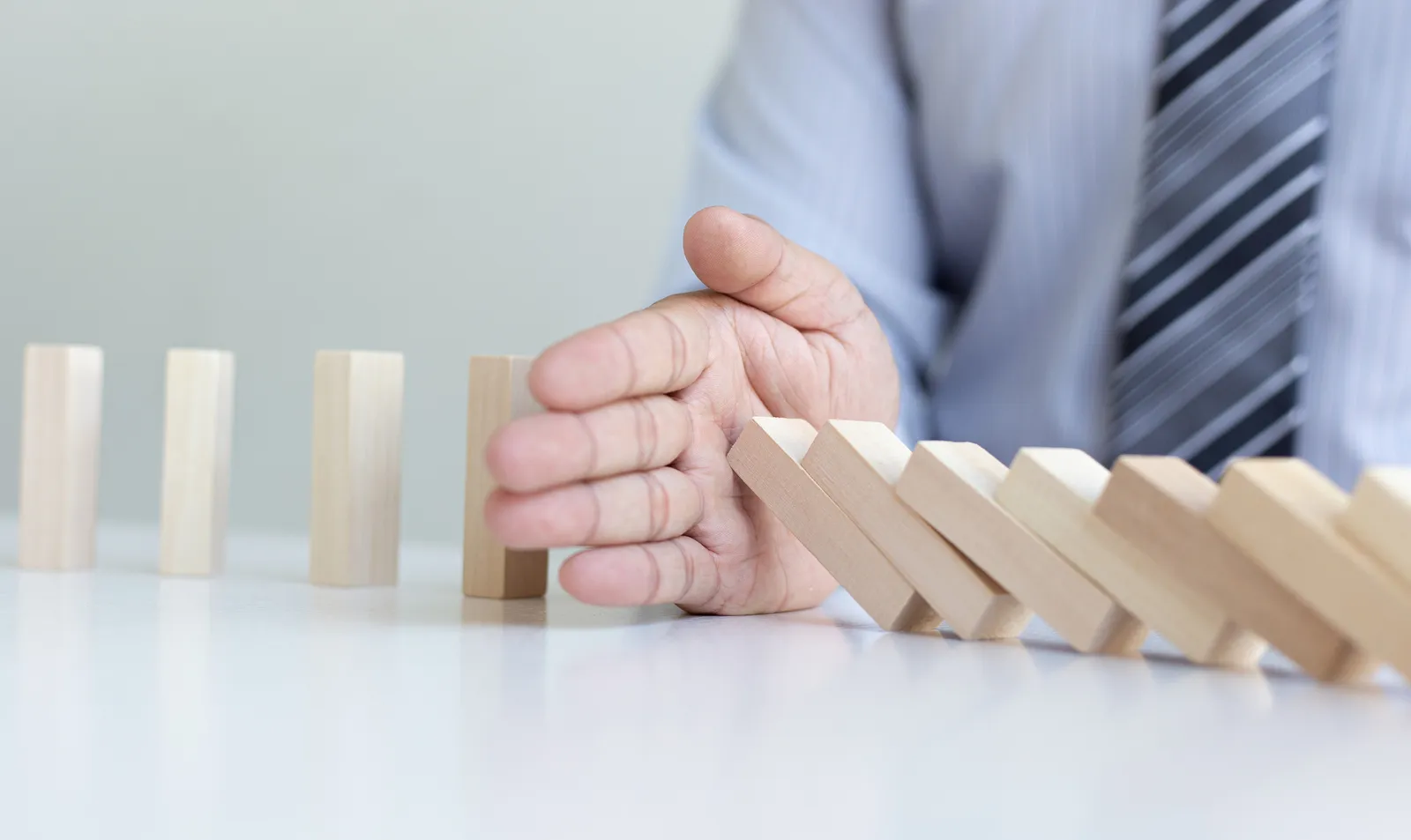hands-young-man-prevent-dominoes-from-falling-reduce-business-risks.jpg hands-young-man-prevent-dominoes-from-falling-reduce-business-risks.jpg